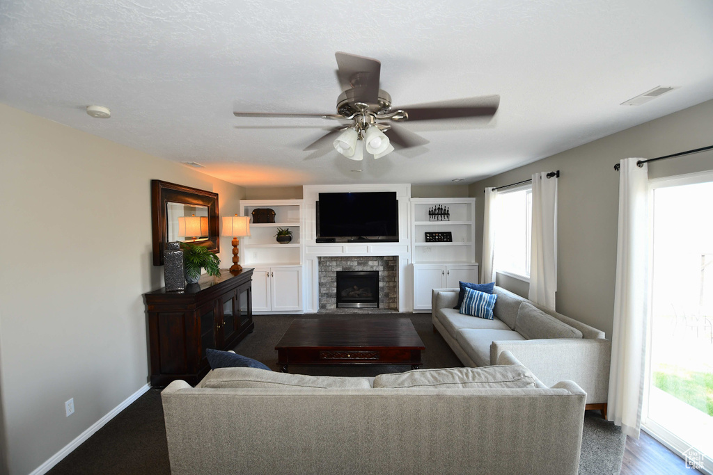 Living room featuring ceiling fan, a wealth of natural light, and carpet