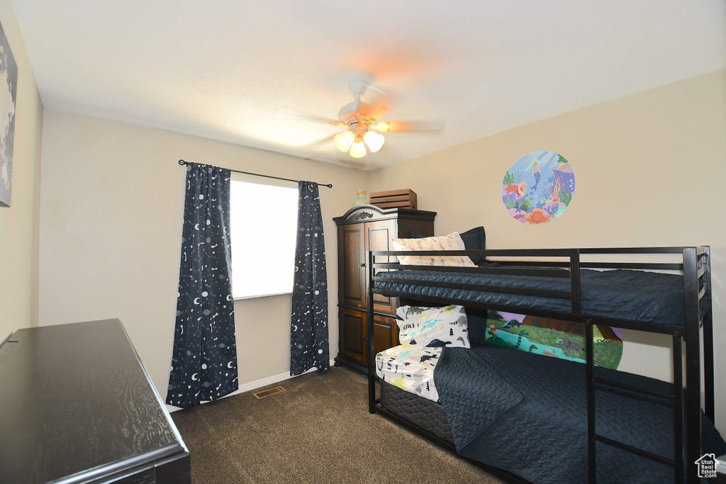 Bedroom with ceiling fan and dark carpet