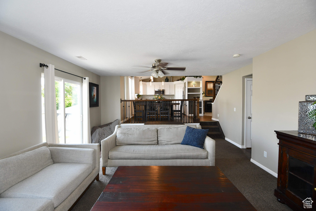 Carpeted living room featuring ceiling fan