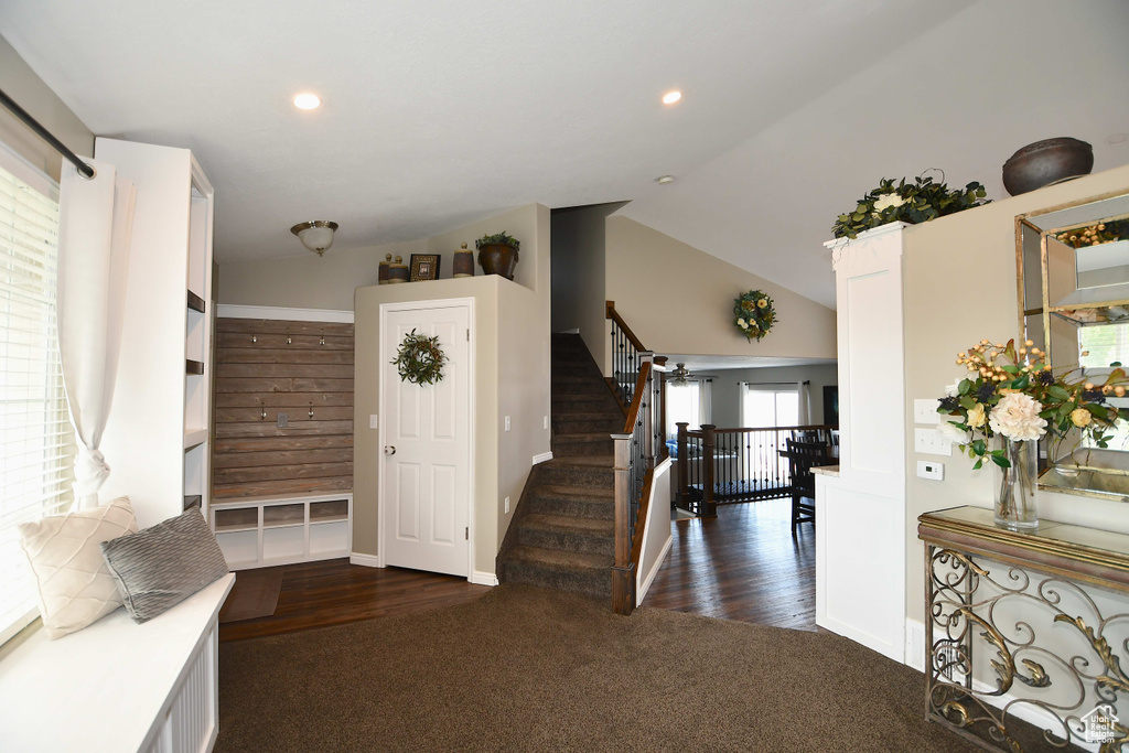 Foyer with high vaulted ceiling and dark wood-type flooring