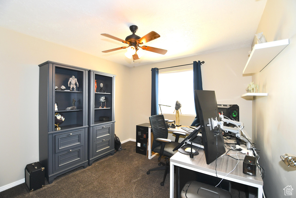 Carpeted home office featuring ceiling fan