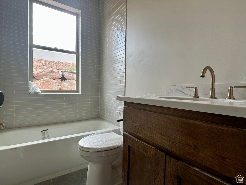 Bathroom featuring vanity, toilet, a tub, and tile patterned floors