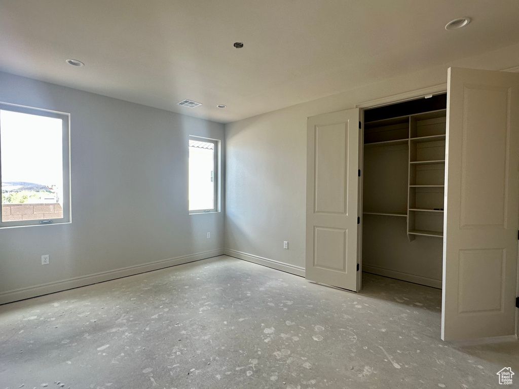 Unfurnished bedroom featuring a closet and multiple windows