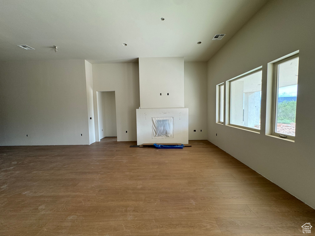 Unfurnished living room featuring a fireplace and light hardwood / wood-style floors