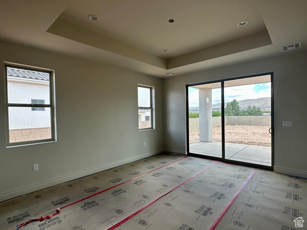 Spare room with a healthy amount of sunlight and a raised ceiling