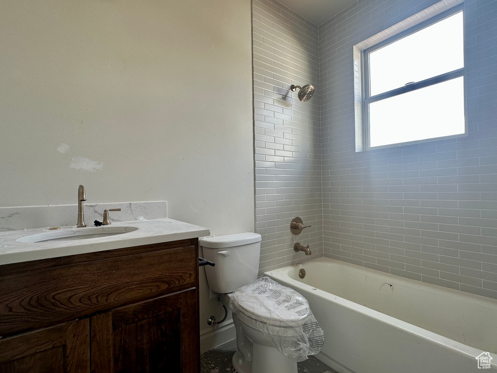 Full bathroom featuring vanity, toilet, and tiled shower / bath combo