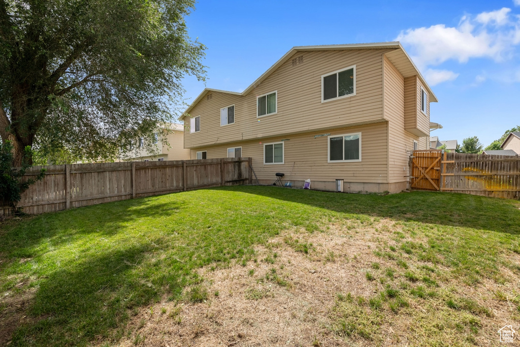 Back of house with a yard