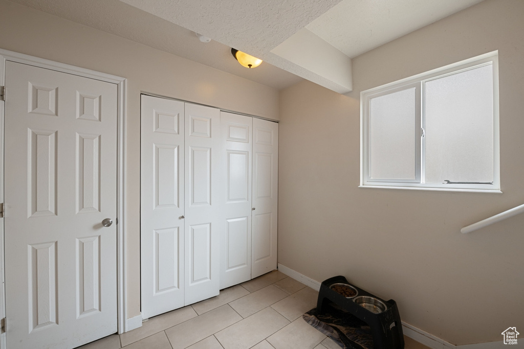 Unfurnished bedroom with light tile patterned floors and a closet