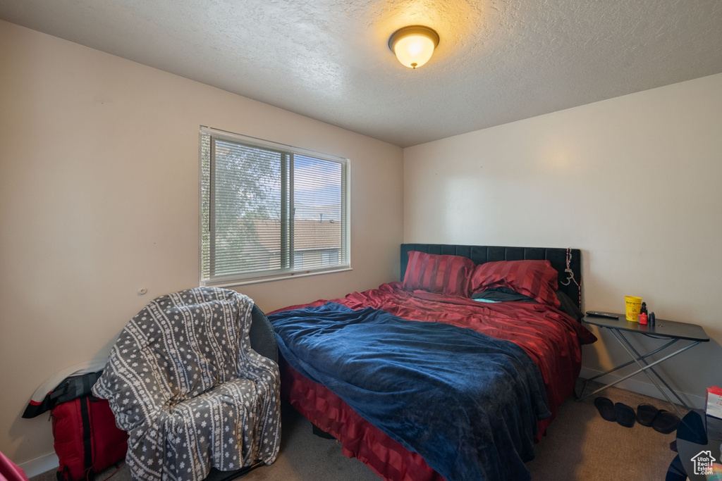 Bedroom with a textured ceiling and carpet flooring