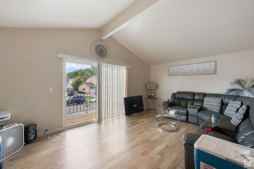 Living room featuring light hardwood / wood-style floors and lofted ceiling with beams