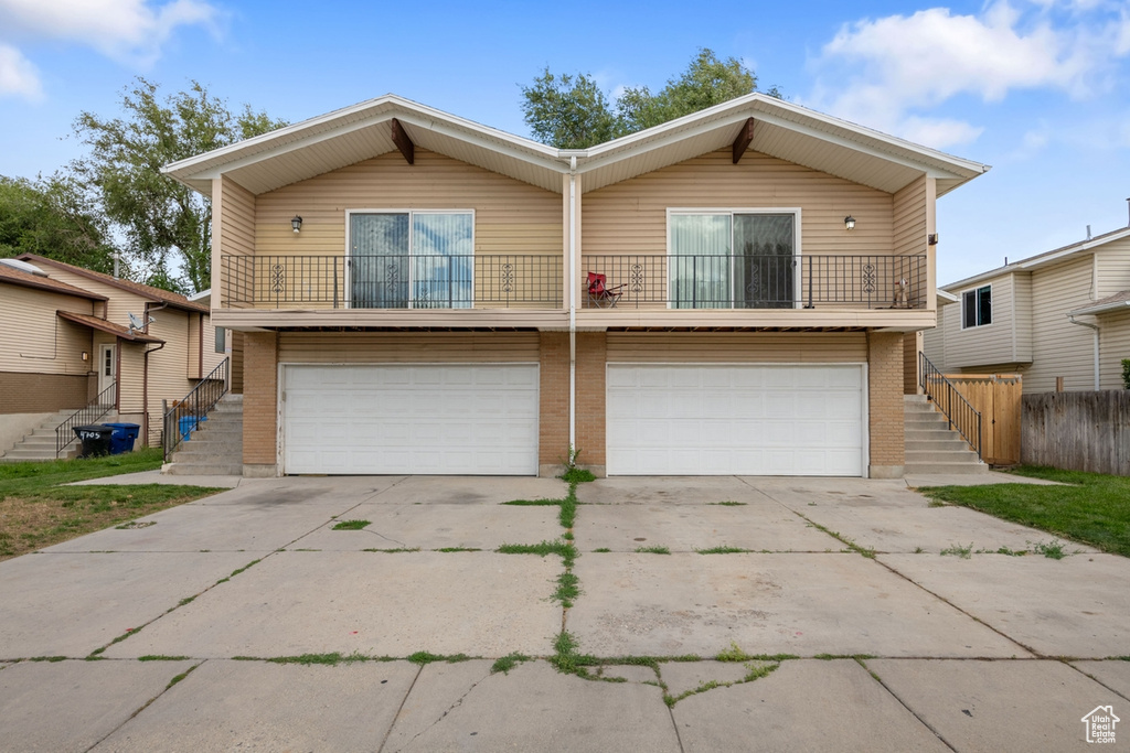 View of front facade featuring a balcony and a garage