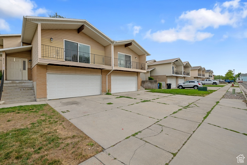 Townhome / multi-family property with a balcony and a garage