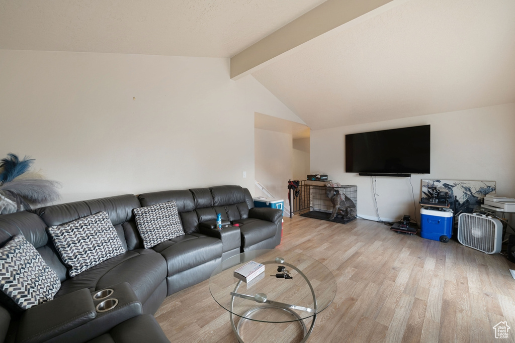 Living room with light hardwood / wood-style floors and lofted ceiling with beams