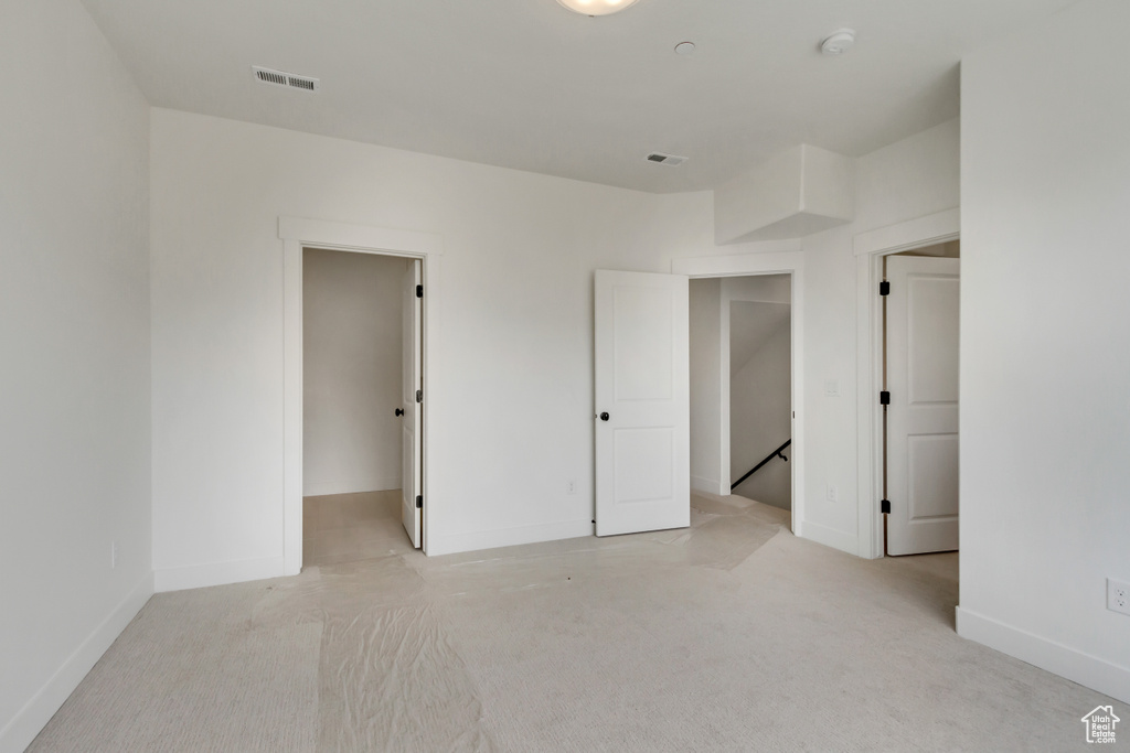 Unfurnished bedroom featuring light colored carpet