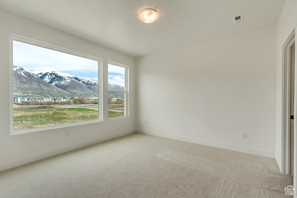 Empty room with a mountain view and light carpet