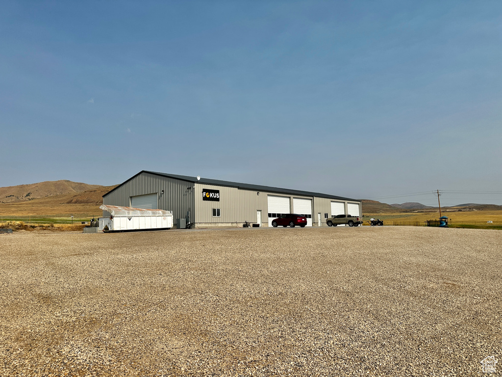 View of front of home featuring a garage, a mountain view, and an outdoor structure