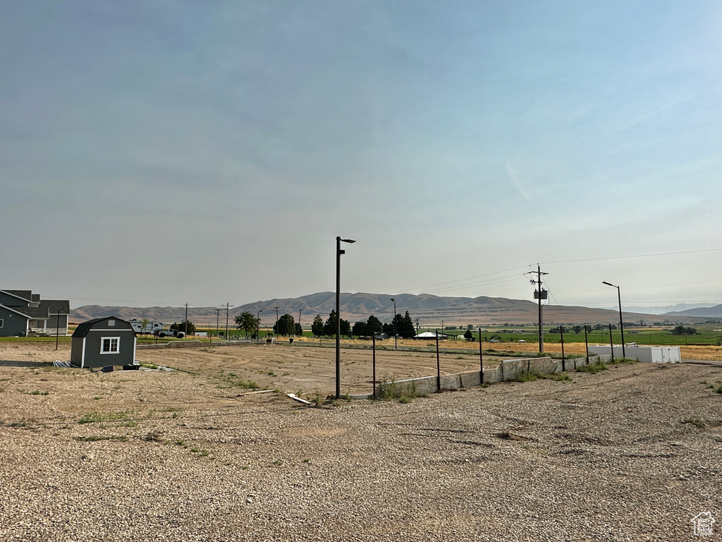 View of yard featuring a storage unit, a rural view, and a mountain view