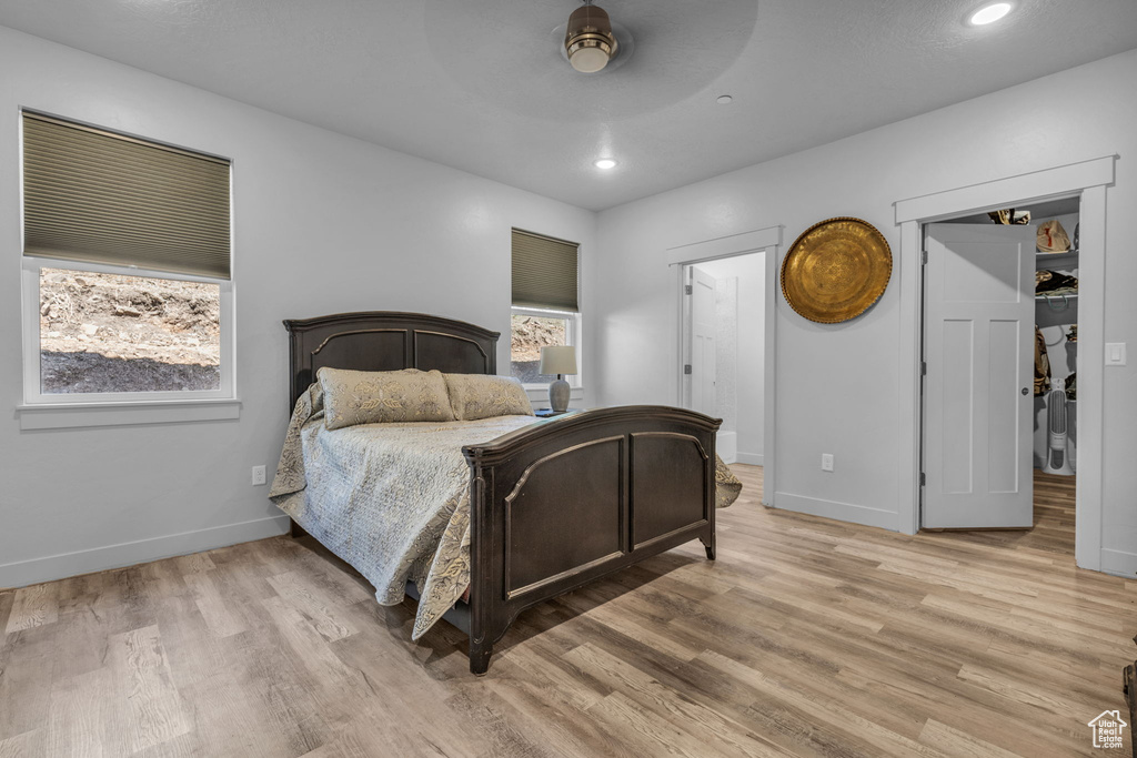 Bedroom with ceiling fan and light wood-type flooring