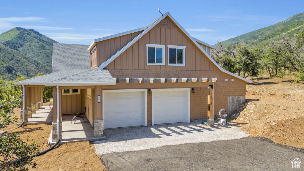 View of front of home with a mountain view and a garage