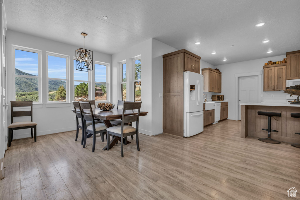 Dining area with a notable chandelier and light hardwood / wood-style flooring