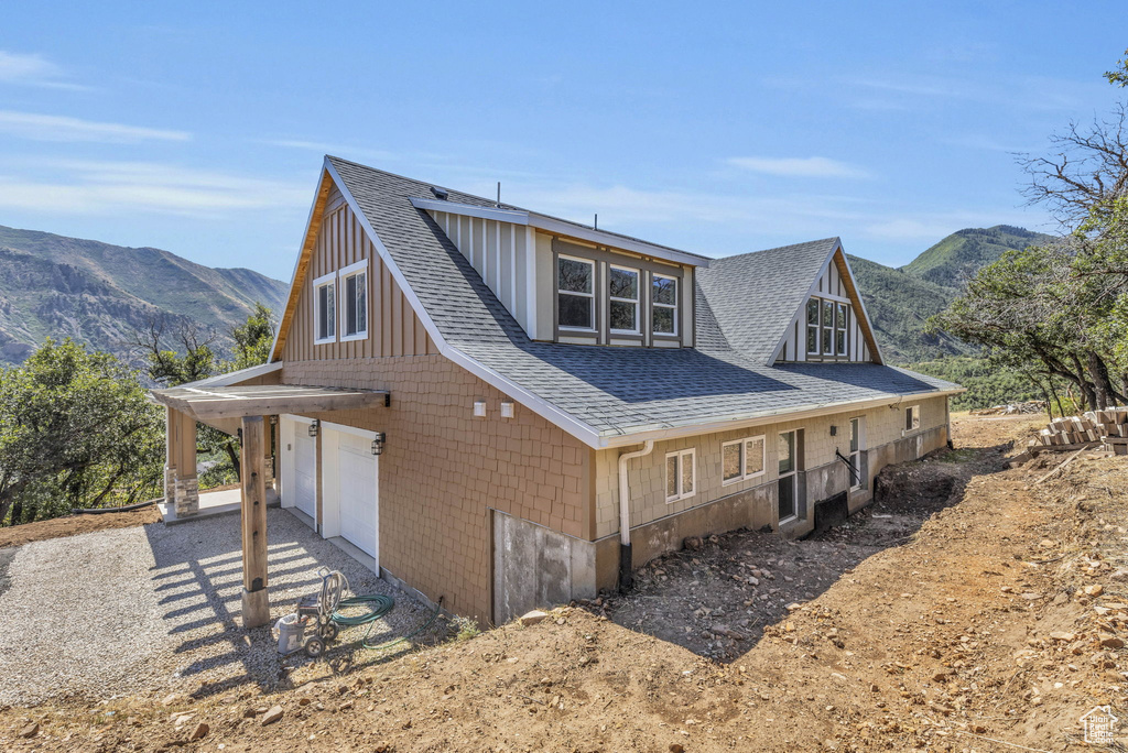 View of property exterior with a mountain view and a garage