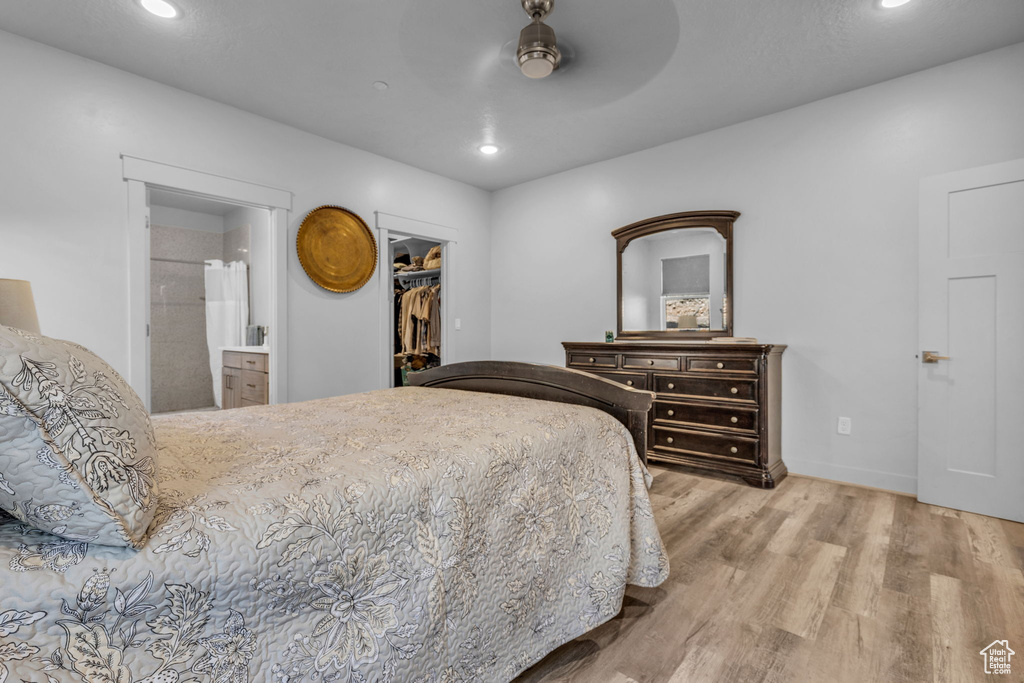 Bedroom featuring a spacious closet, a closet, ceiling fan, connected bathroom, and hardwood / wood-style flooring