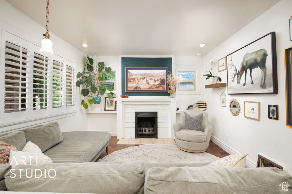 Living room with a fireplace, light hardwood / wood-style floors, and a healthy amount of sunlight