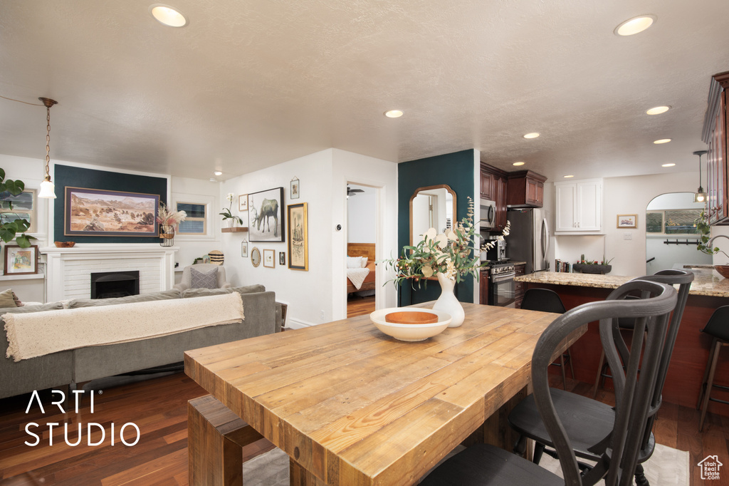 Dining space featuring a fireplace, dark wood-type flooring, and sink