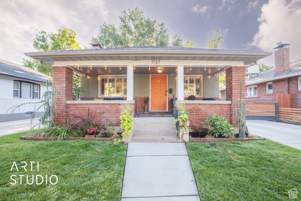 Bungalow-style home featuring a front lawn and a porch