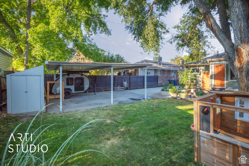 Back of house featuring a storage unit and a yard