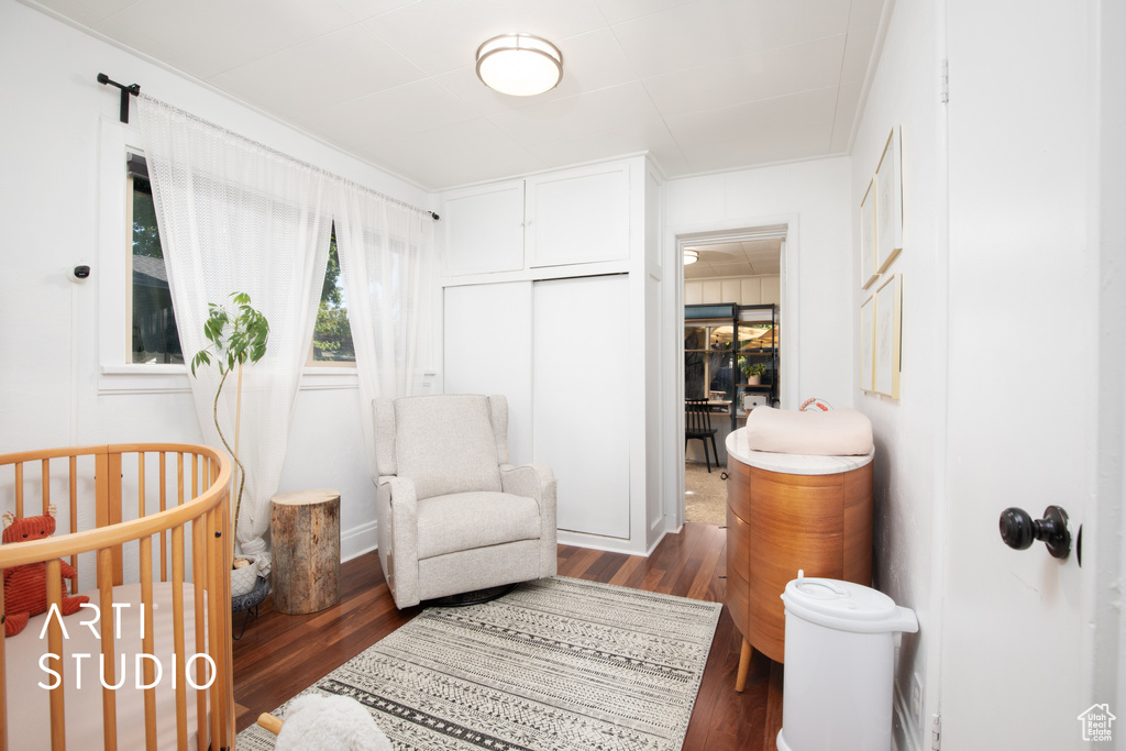 Bedroom with a crib and wood-type flooring