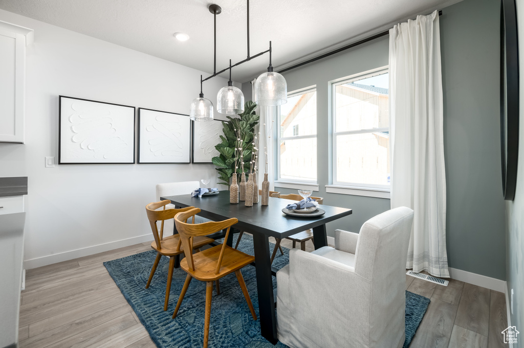 Dining space with light hardwood / wood-style flooring