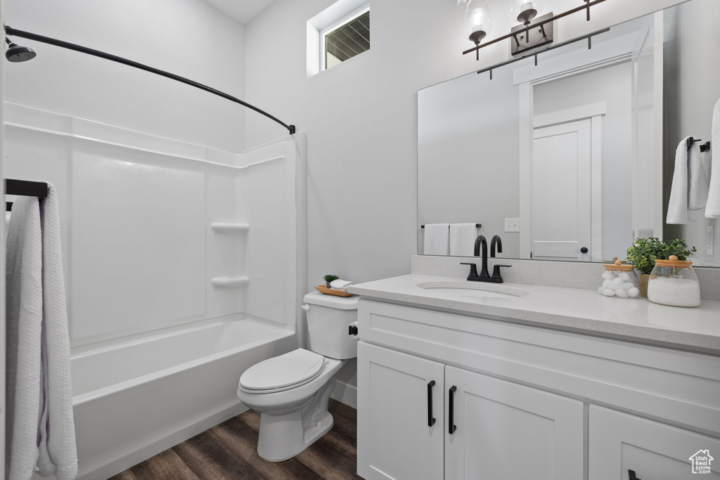 Full bathroom with shower / bathing tub combination, vanity, toilet, and wood-type flooring