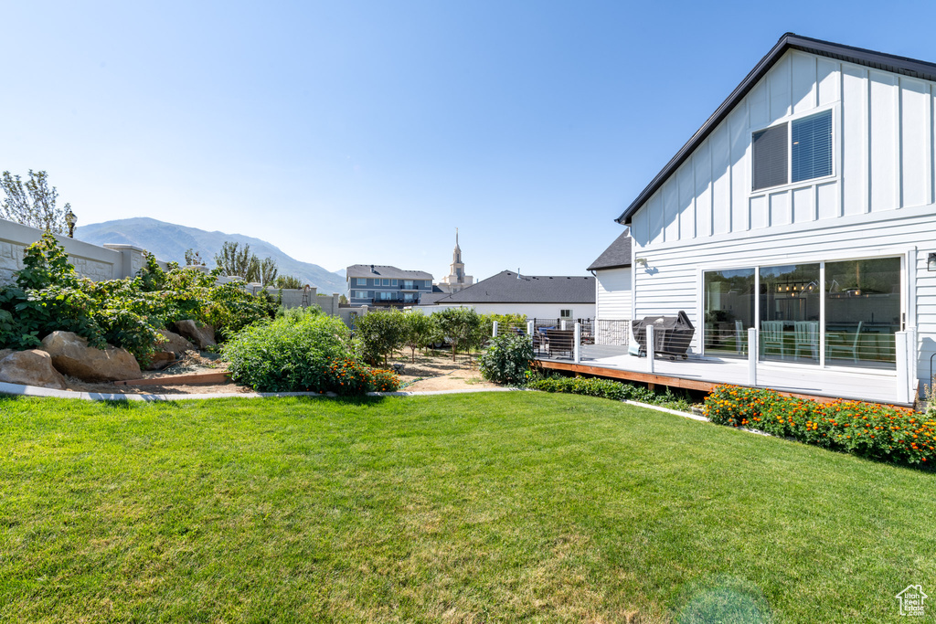 View of yard with a deck with mountain view