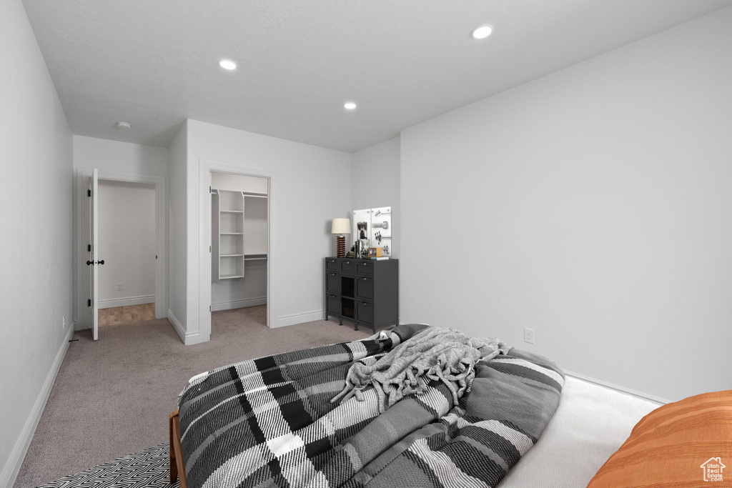 Carpeted bedroom featuring a closet and a spacious closet