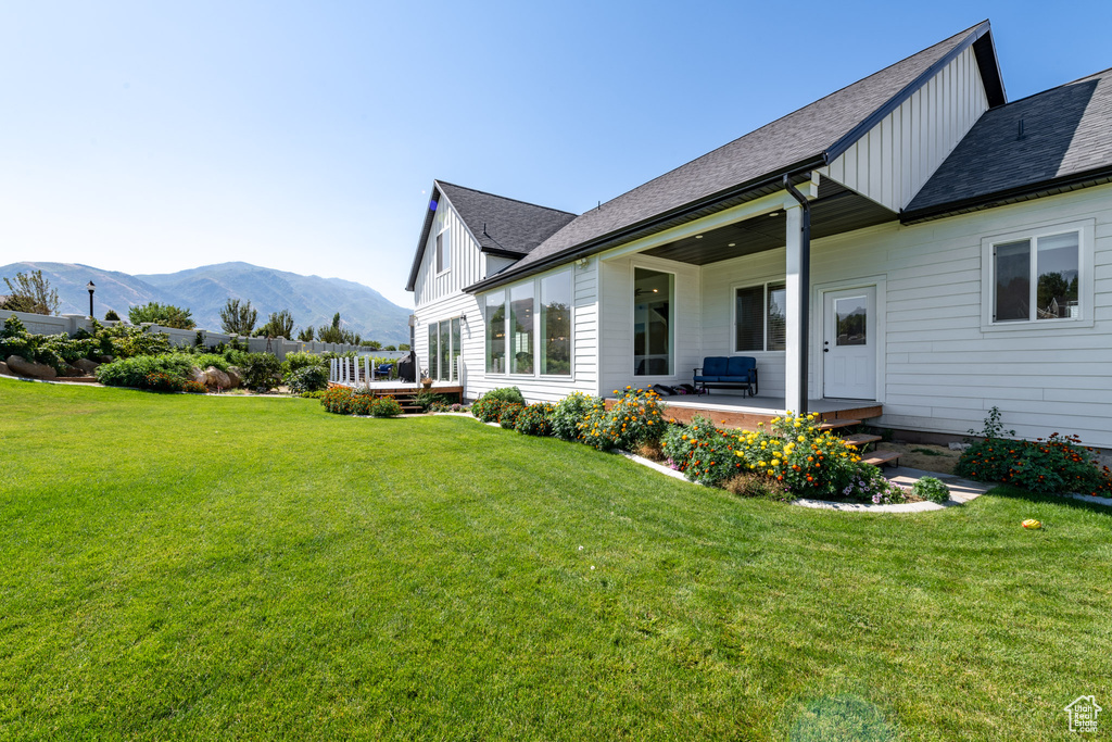 Back of house featuring a yard, a patio, and a mountain view