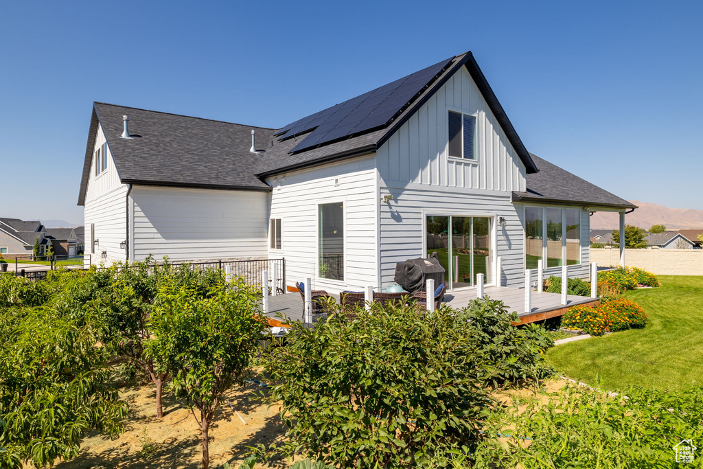 Rear view of property with a yard and a deck