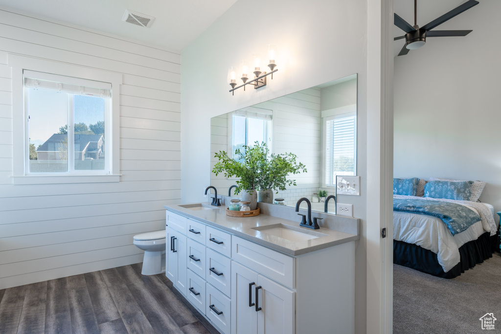 Bathroom featuring vanity, toilet, plenty of natural light, and wood-type flooring