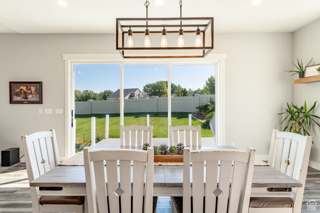 Dining area featuring a wealth of natural light, hardwood / wood-style floors, and a chandelier