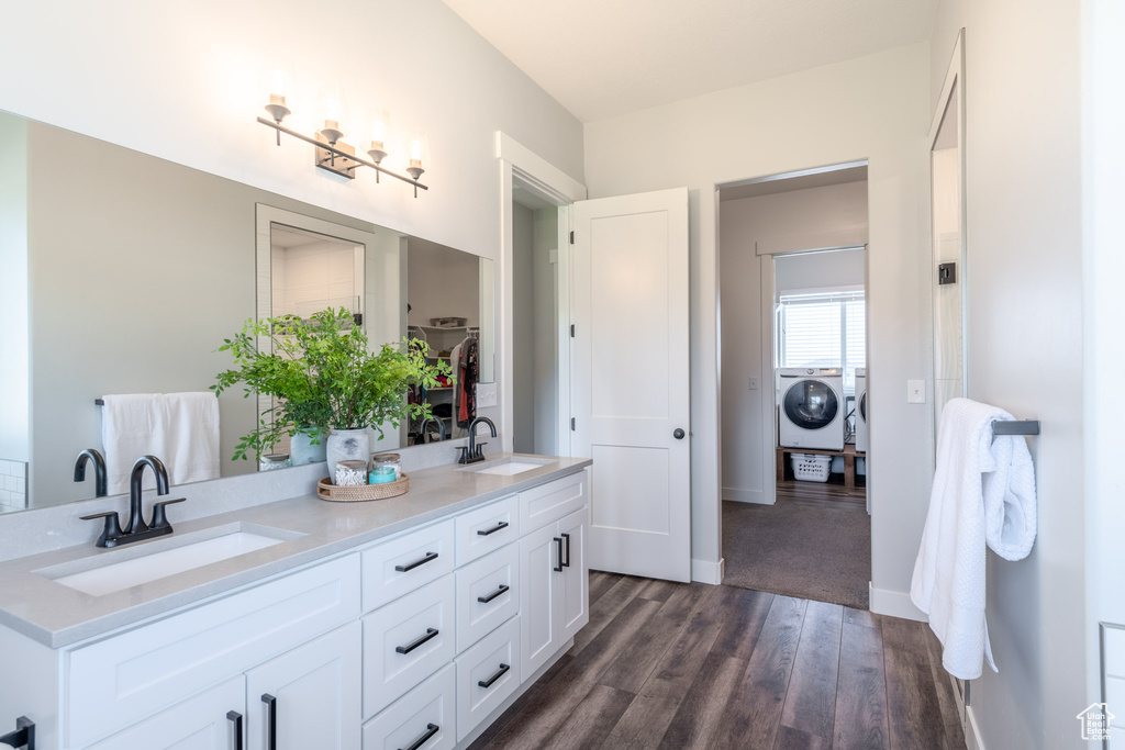 Bathroom with vanity, independent washer and dryer, and wood-type flooring