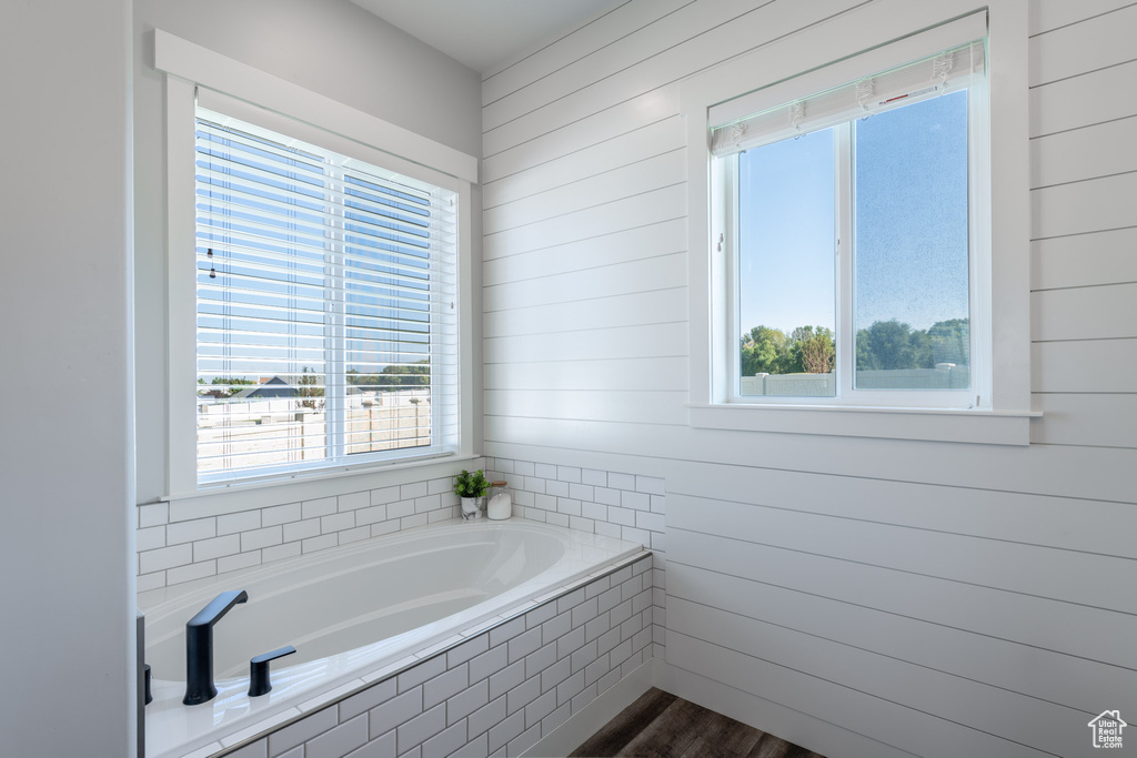 Bathroom with wood-type flooring and tiled tub