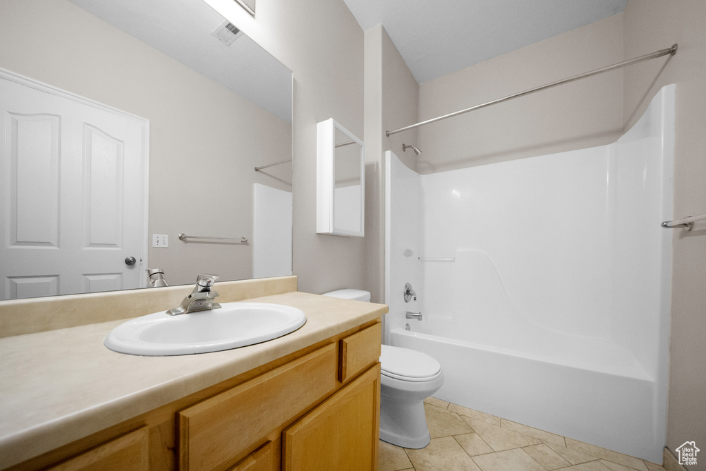 Full bathroom featuring shower / bathtub combination, toilet, vanity, and tile patterned floors