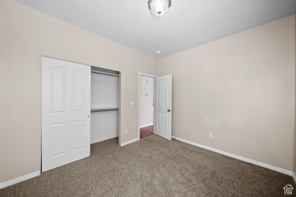 Unfurnished bedroom with a closet and carpet