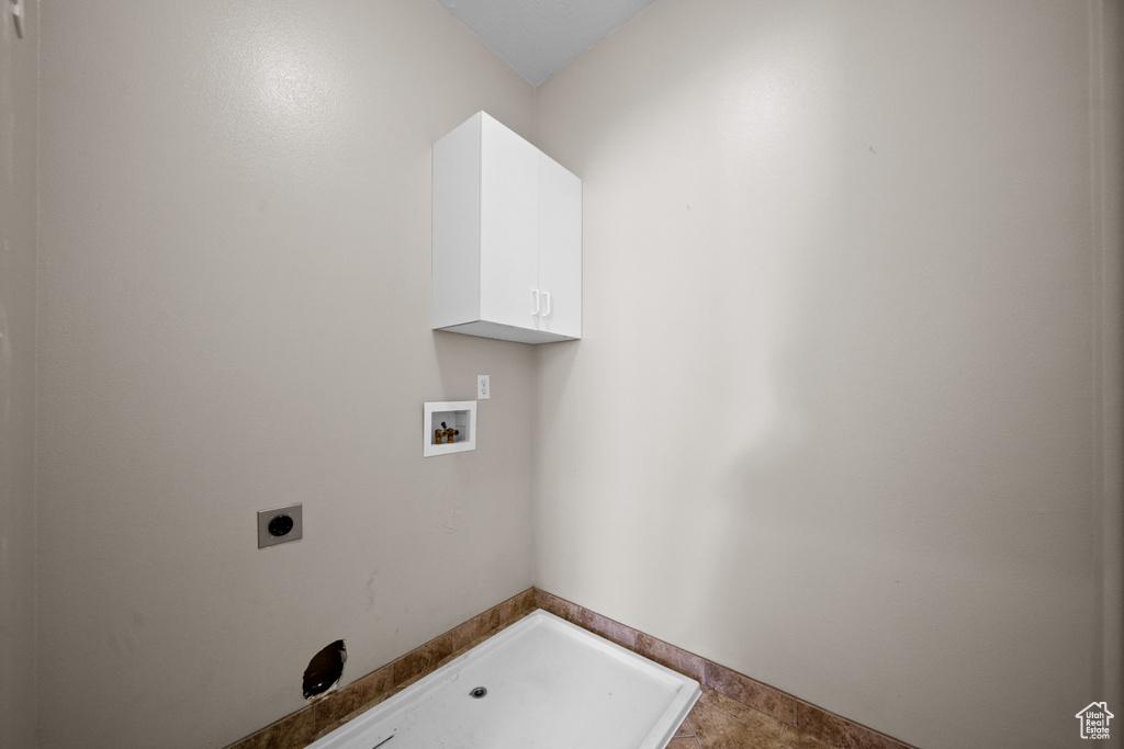 Clothes washing area with hookup for an electric dryer, hookup for a washing machine, and cabinets