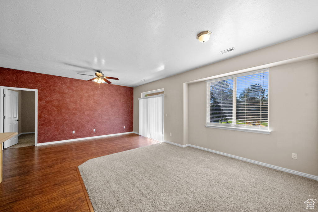 Empty room with ceiling fan and hardwood / wood-style floors