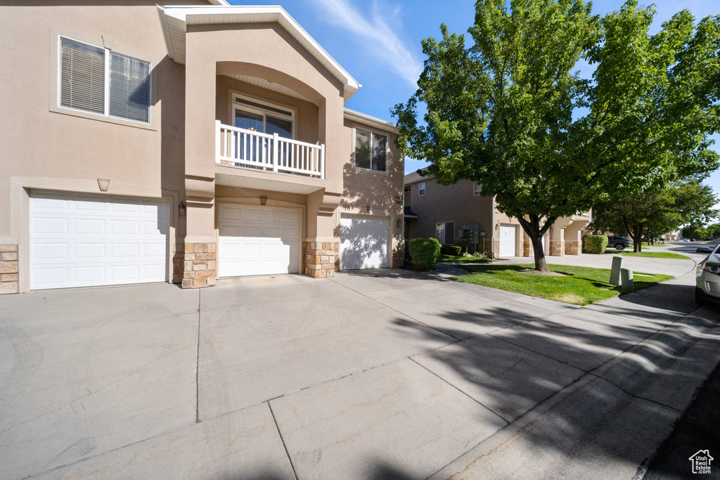 View of front facade featuring a balcony and a garage