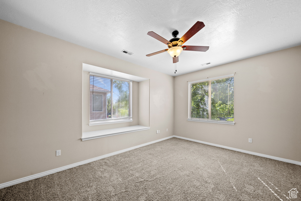 Carpeted empty room with ceiling fan