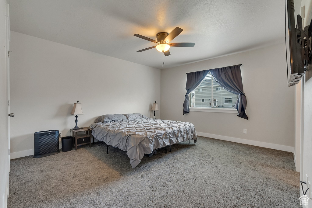 Bedroom with ceiling fan and carpet