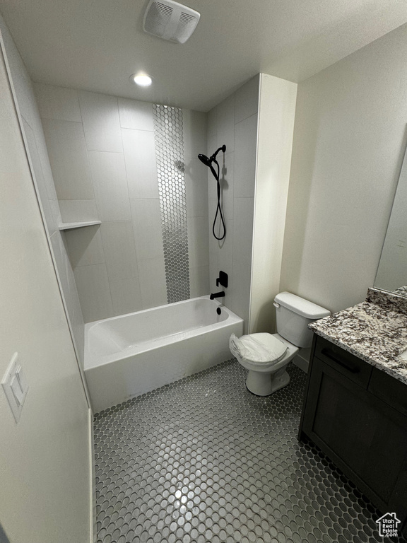 Full bathroom featuring tile patterned flooring, toilet, tiled shower / bath, and vanity