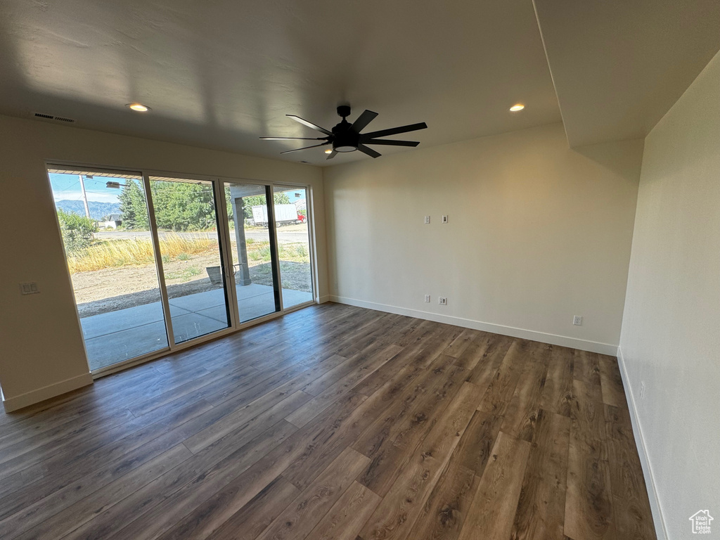 Empty room with plenty of natural light, ceiling fan, and dark hardwood / wood-style floors